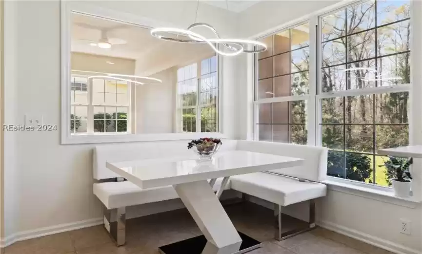Dining area with light tile flooring and a notable chandelier