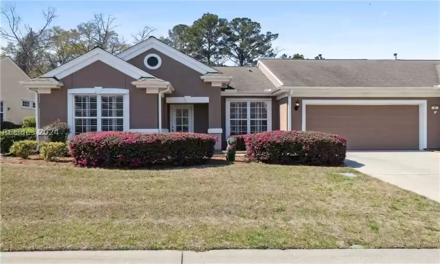 Single story home with a garage and a front yard