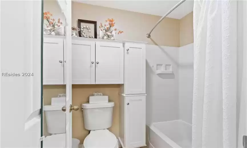 Bathroom with shower / tub combo with curtain and toilet