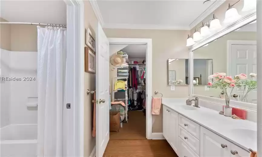 Bathroom featuring ornamental molding, shower / bath combo, double sink vanity, and hardwood / wood-style floors