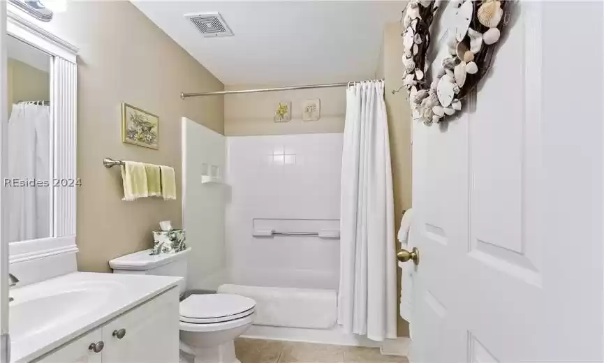 Full bathroom near bedroom 3 with toilet, vanity with extensive cabinet space, tile flooring, and shower / bath combination with curtain