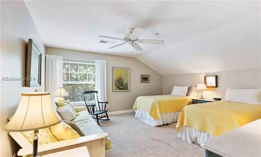 Primary Bedroom 2 with light carpet, ceiling fan, and vaulted ceiling. Top floor privacy.