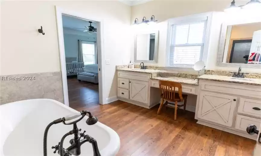 Bathroom with a deep soaker tub and separate shower leads to a spacious closet.