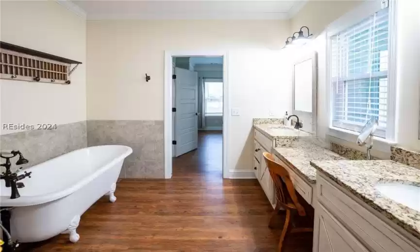 Bathroom with dual sinks, claw foot soaker tub, and separate shower.