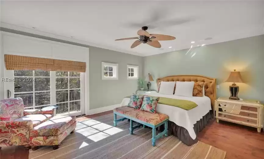Ensuite Bedroom with ceiling fan, crown molding, hardwood flooring