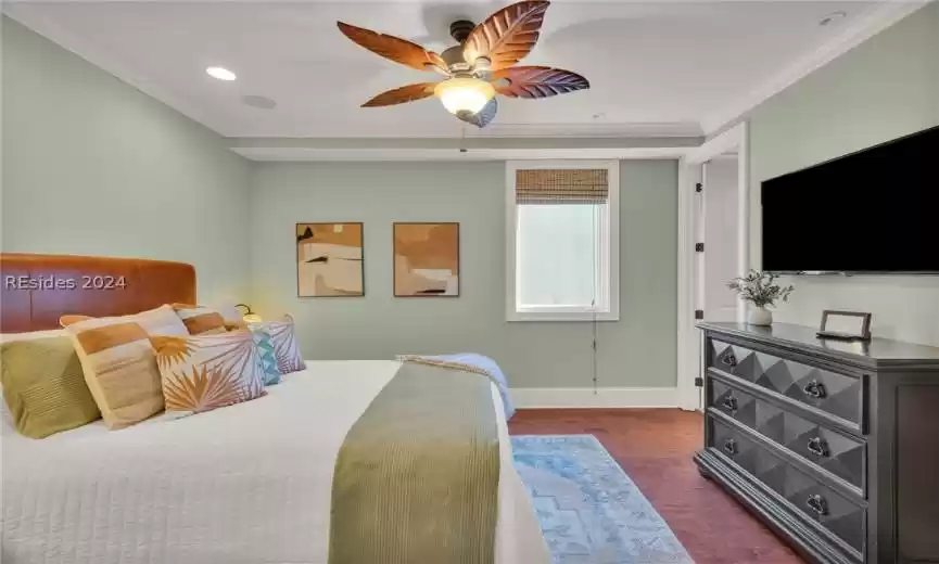 Bedroom featuring ceiling fan, ornamental molding, and hardwood flooring
