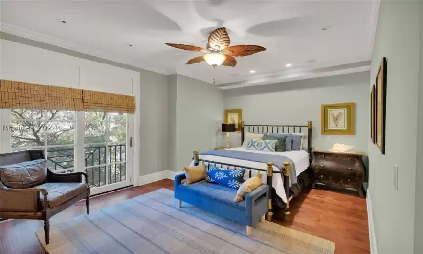 Ensuite Bedroom featuring ceiling fan, ornamental molding, and  hardwood floors