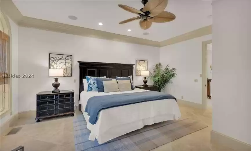 1st floor Bedroom w/ceiling fan, crown molding, and Stone floors