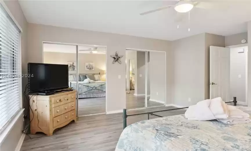 Primary bedroom with large flat screen TV and two large closets -- his n' hers.