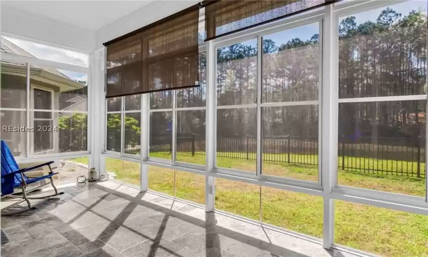 Spacious master bedroom features a sitting area with view of lagoon and woods.