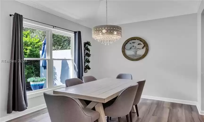 Open concept family room/great room features attractive luxury vinyl plank flooring, ceiling fan/light, and fireplace. (Custom double sliders to four season porch).