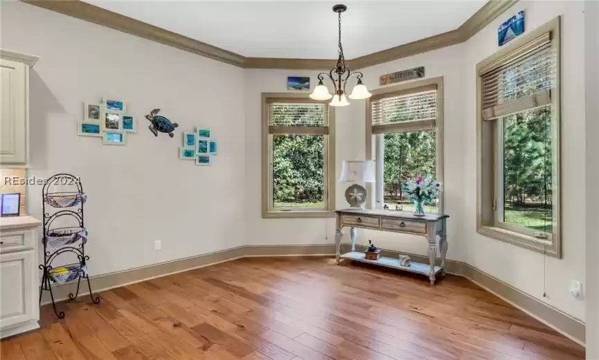 Large, attractive dining room/dining area off the kitchen features three large windows that let in the natural light ... the wood floors continue to sparkle and shine.