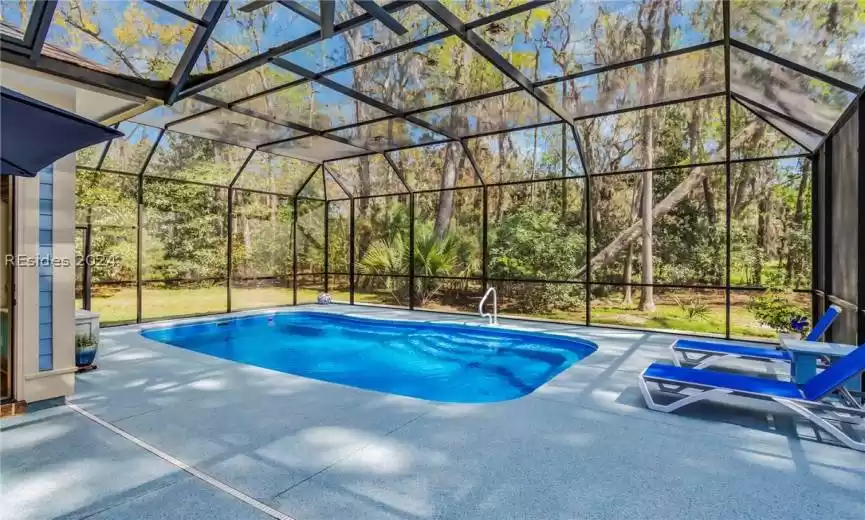 Custom pool enclosure for indoor comfort whether swimming, snacking, or entertaining. Epoxy coating to pool deck and easy access with built-in steps/seating on shallow end and deep end.