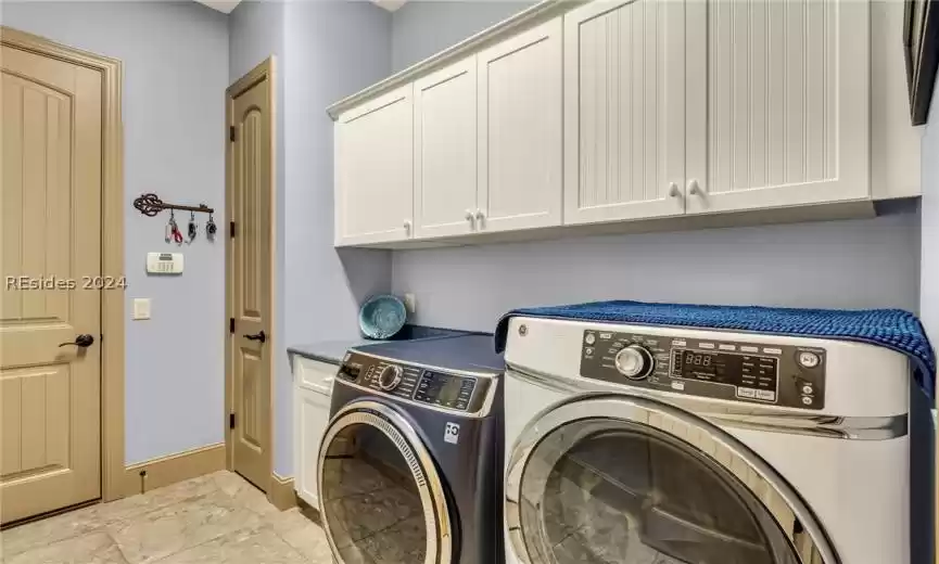 Laundry room with front open washer and dryer and lots of storage. (New GE washer in 2023).