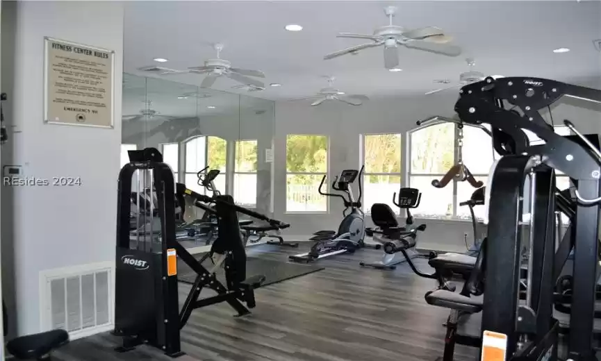 Workout area featuring ceiling fan and dark wood-type flooring