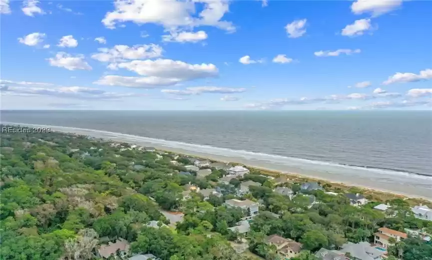 Birds eye view of property featuring a water view and a view of the beach