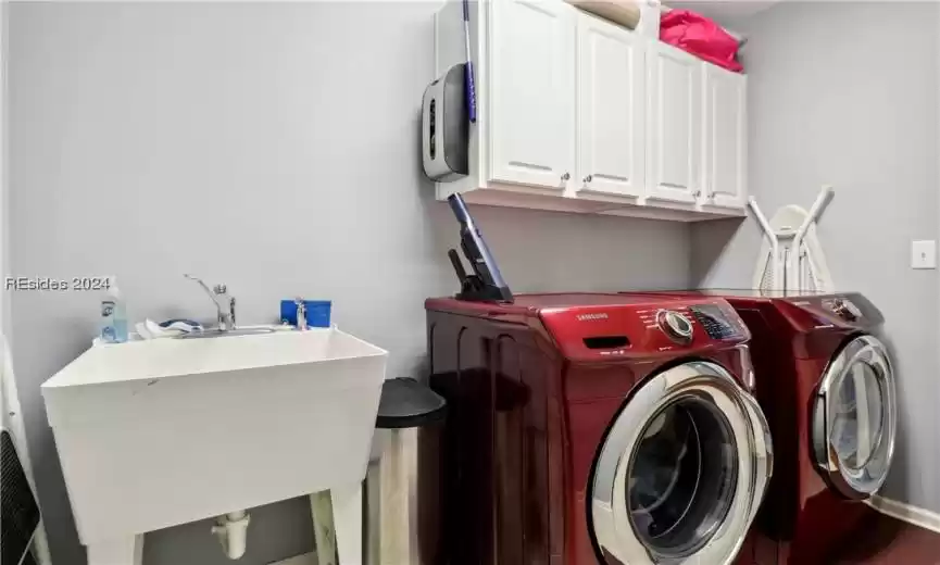 Laundry area featuring cabinets, sink, and independent washer and dryer