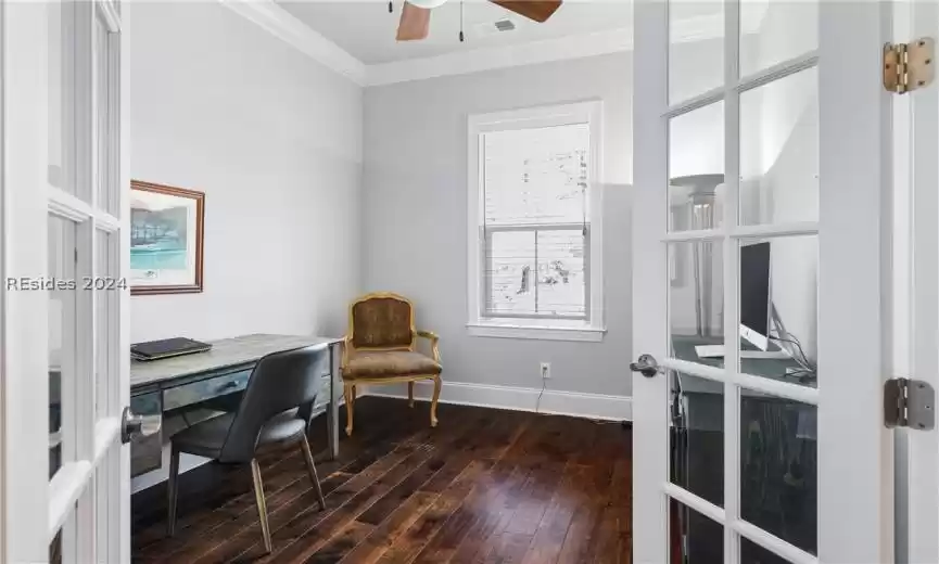 Office space with french doors, crown molding, ceiling fan, and dark hardwood / wood-style flooring