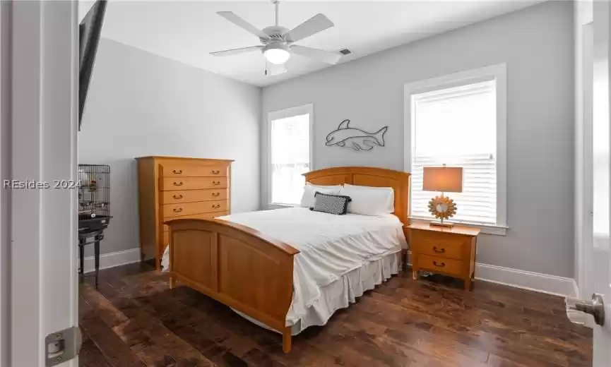 Bedroom with ceiling fan and dark hardwood / wood-style flooring