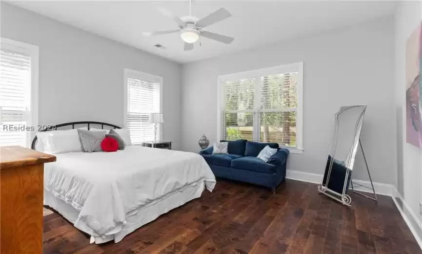 Bedroom with dark hardwood / wood-style floors and ceiling fan