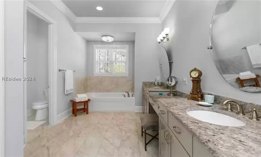 Bathroom with toilet, large vanity, a bathing tub, ornamental molding, and tile floors
