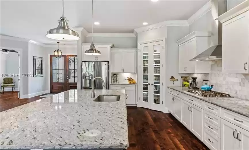 Kitchen with dark hardwood / wood-style floors, tasteful backsplash, ceiling fan, and appliances with stainless steel finishes