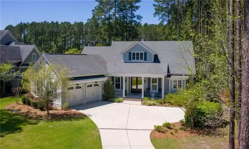 New england style home with a front yard and a garage