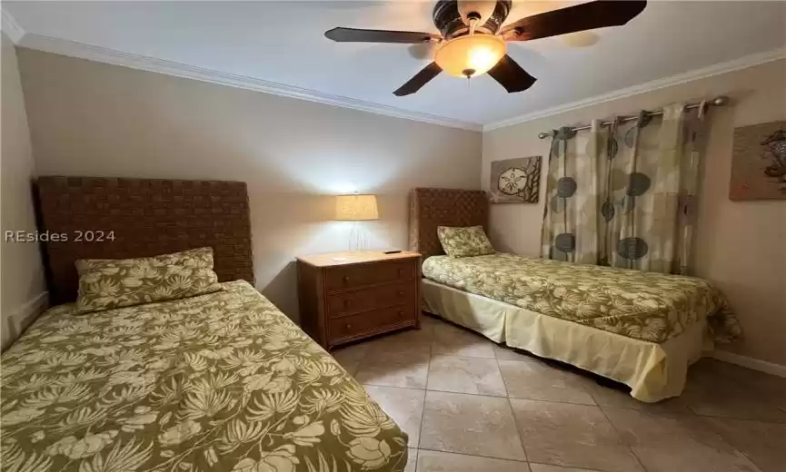 Bedroom featuring ornamental molding, ceiling fan, and light tile floors