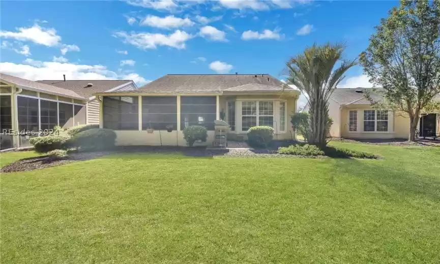 Back of property with a yard and a sunroom