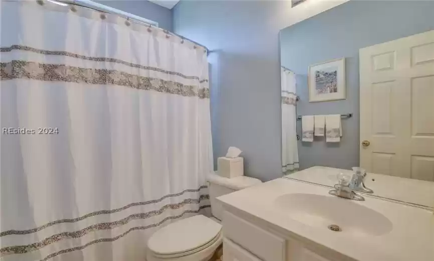 Guest bathroom featuring shower/tub combo and vanity with extensive cabinet space