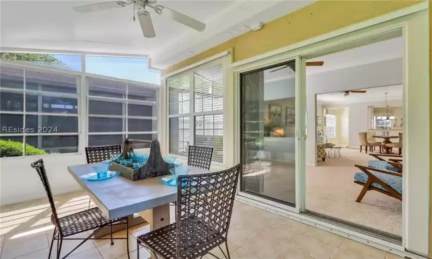 Three season sunroom with ceiling fan and plenty of natural light with vinyl/screen windows