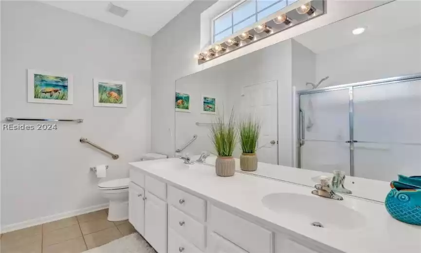 Bathroom featuring dual vanity, tile flooring, and toilet