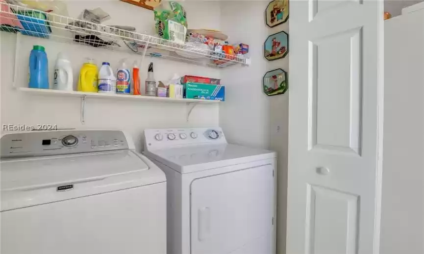 Laundry area with washing machine and clothes dryer and shelving