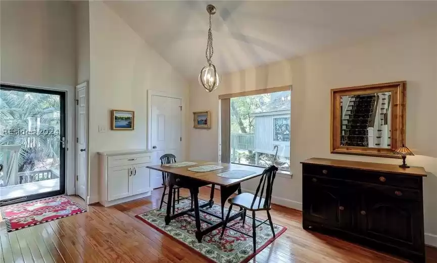 Dining space with a notable chandelier, light hardwood / wood-style flooring, and high vaulted ceiling