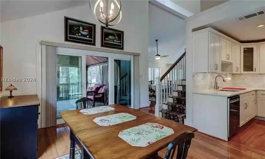 Dining area with sink, dark hardwood / wood-style flooring, plenty of natural light, and ceiling fan with notable chandelier