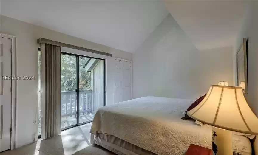 Bedroom with lofted ceiling, access to exterior, and a closet