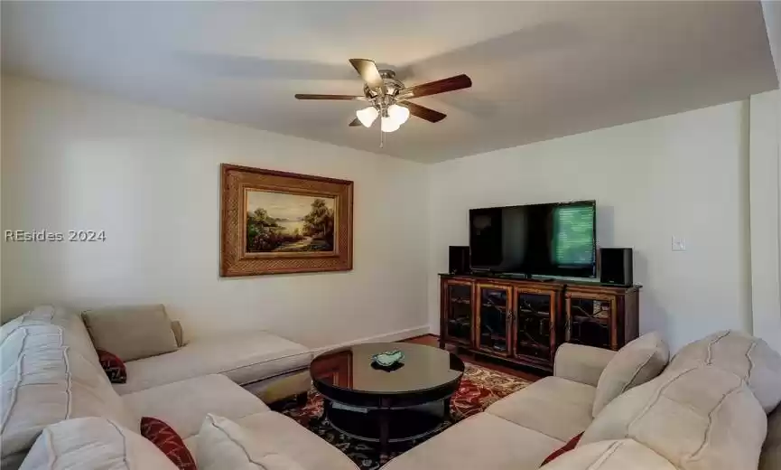 Living room with ceiling fan and hardwood / wood-style floors