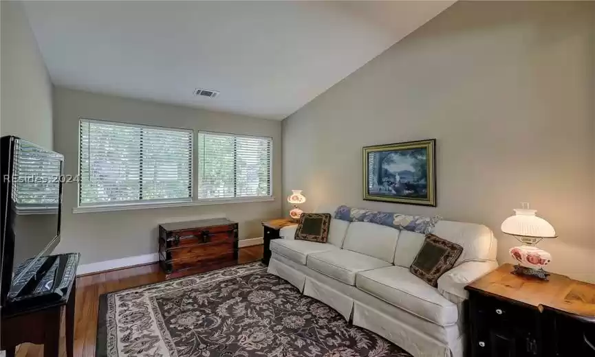 Living room featuring dark hardwood / wood-style floors and vaulted ceiling