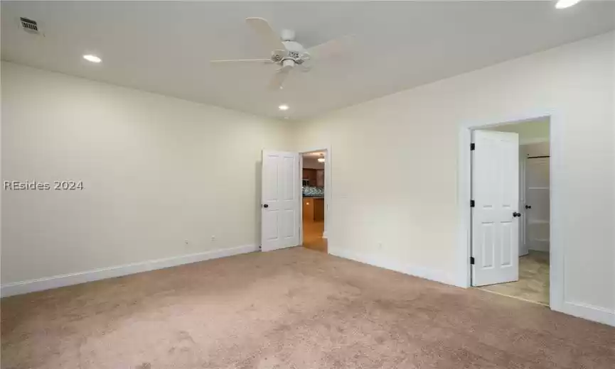 Unfurnished bedroom featuring ceiling fan and light colored carpet