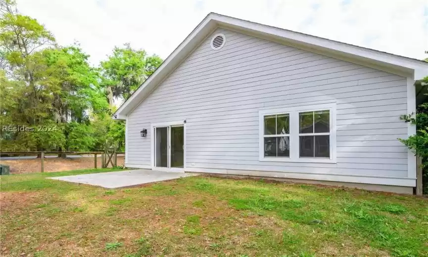 Rear view of property with a lawn and a patio area