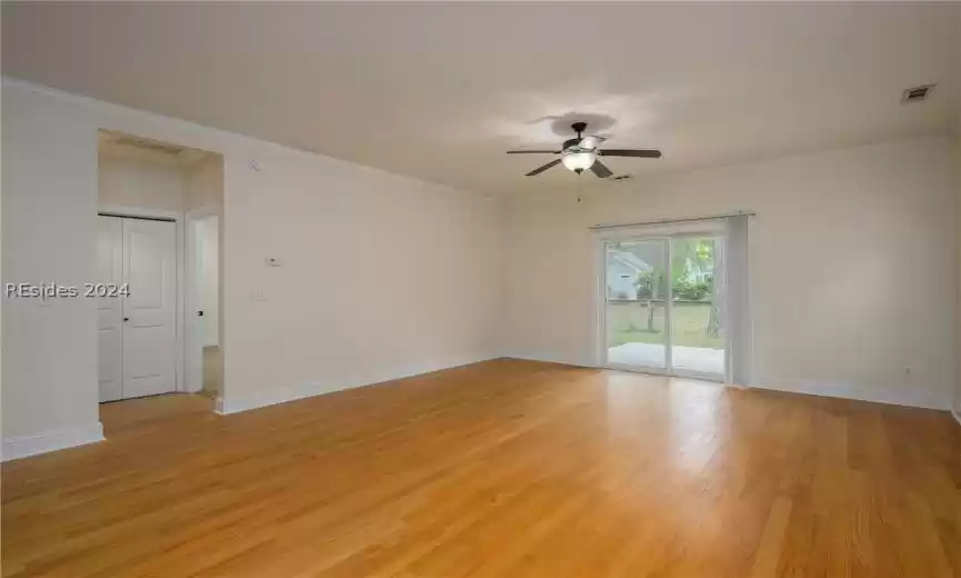 Empty room with ornamental molding, ceiling fan, and light wood-type flooring