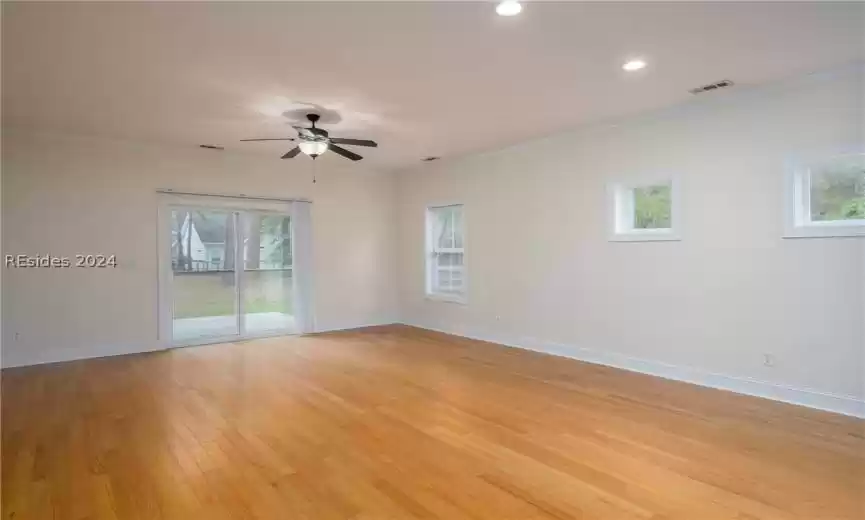 Spare room with ceiling fan, crown molding, and light wood-type flooring