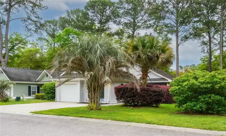 View of front facade featuring a front lawn and a garage