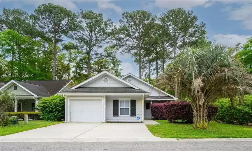 Ranch-style house with a front yard and a garage