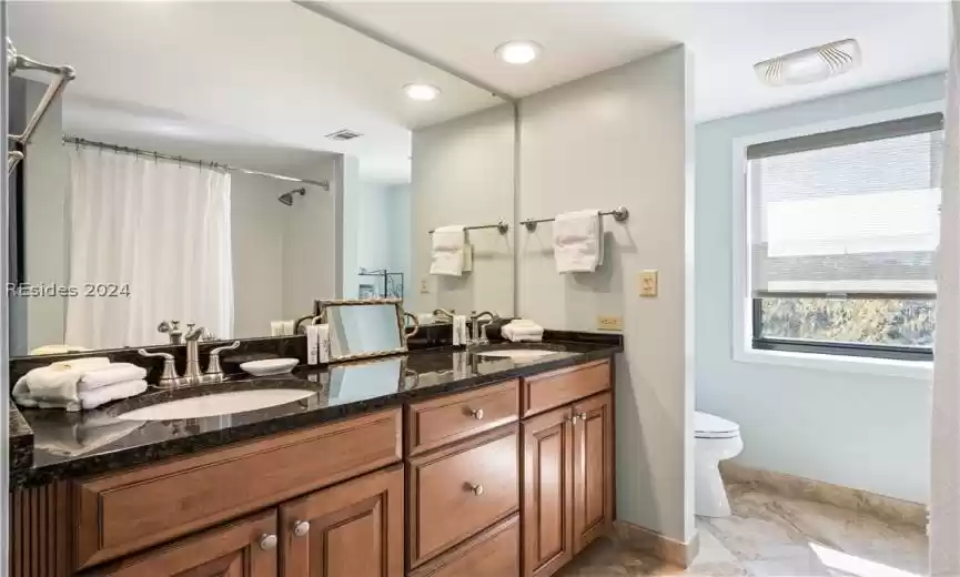 2nd bathroom, with dual vanities, granite countertops, and travertine tile flooring.