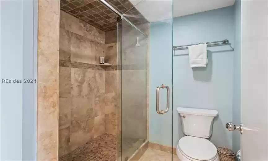 Completely stoned tile shower, with glass door entry.
