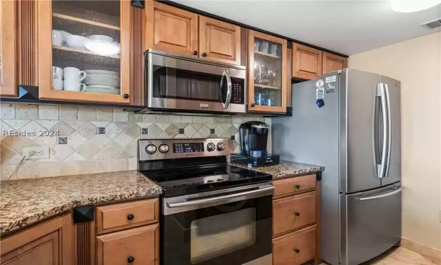 Stainless steel appliances, with glass enclosed cabinetry.