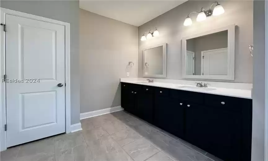 Kitchen featuring hanging light fixtures, stainless steel appliances, light stone counters, hardwood / wood-style flooring, and a kitchen island with sink