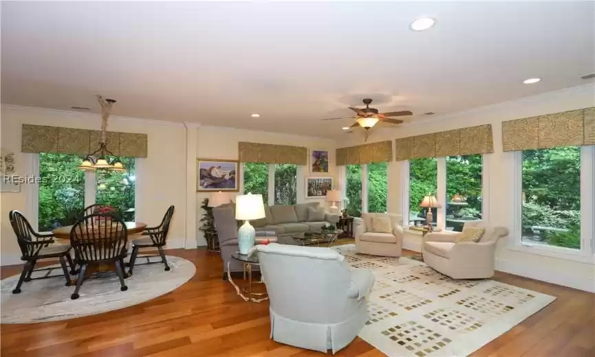 Great/leisure room with crown molding, ceiling fan with notable chandelier over the casual dining area, and 5