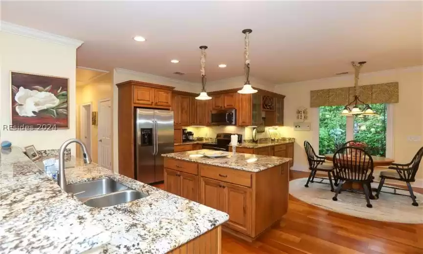 Kitchen with stainless steel appliances, a kitchen island, decorative pendant light fixtures, 5